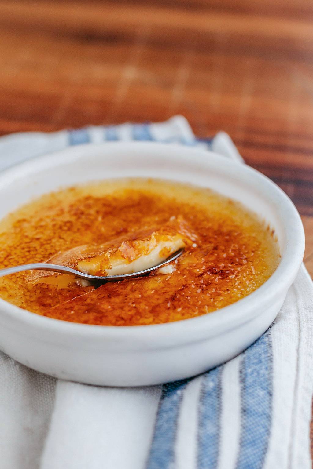 Close up oof a spoon digging into creme brule